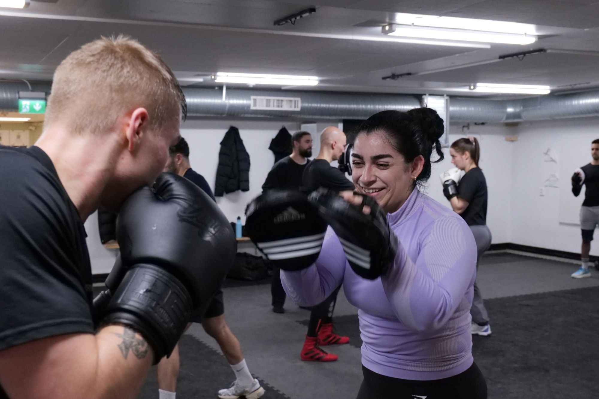 Leende boxare håller mittsar under Basics & Burn