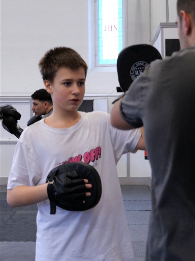 Young boxer training on pads